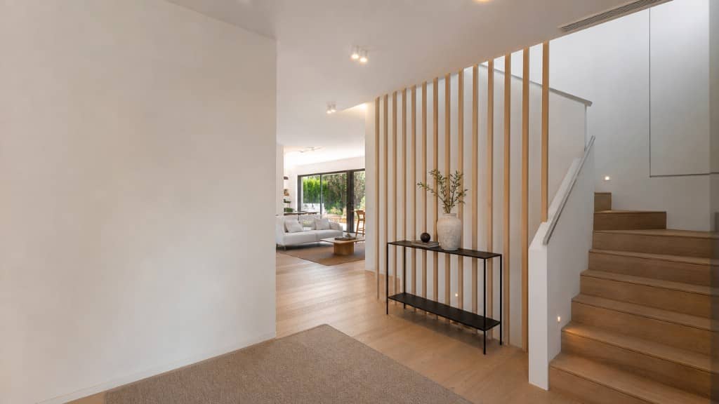 Entrada de chalet con celosía de madera y escalera iluminada